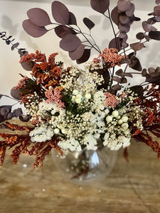 Aliénor est un bouquet haut et chaud autour du gypsophile et statice crème orné de soligado rouge et d'eucalyptus populus et baby rouge orangé.   De la tendresse médiévale pour ce bouquet.