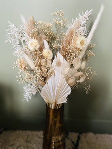 Sidonie est un joli bouquet blanc, tendre, doux et vaporeux. Il est composé autour des hélychrisum blanches, des palmes blanches, du ruscus, des lagurus et pampas naturelles avec pour le côté vaporeux du gypsophile crême. 