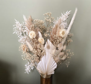 Sidonie est un joli bouquet blanc, tendre, doux et vaporeux. Il est composé autour des hélychrisum blanches, des palmes blanches, du ruscus, des lagurus et pampas naturelles avec pour le côté vaporeux du gypsophile crême. 